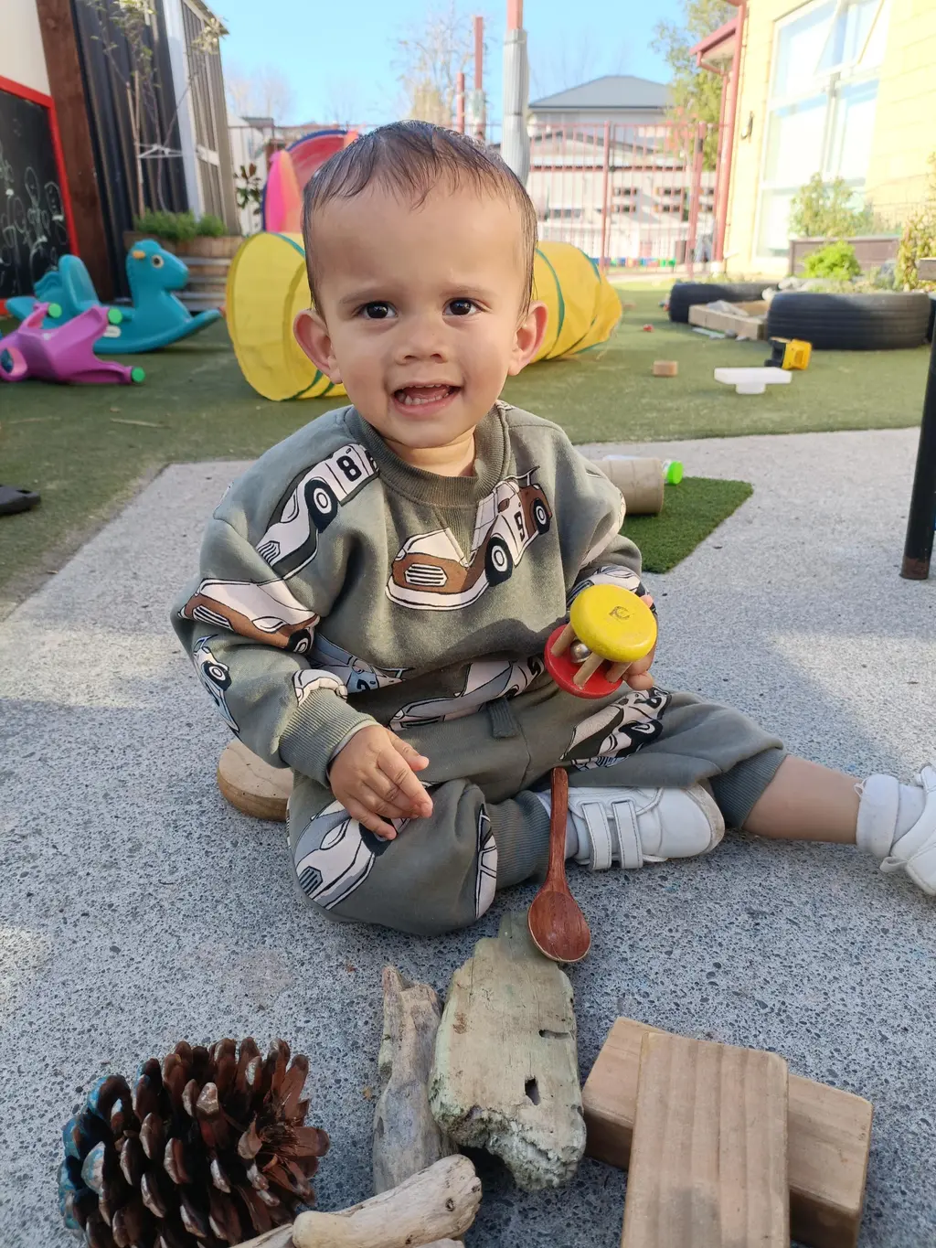 Harmony Haven toddler playing outdoors with natural loose parts
